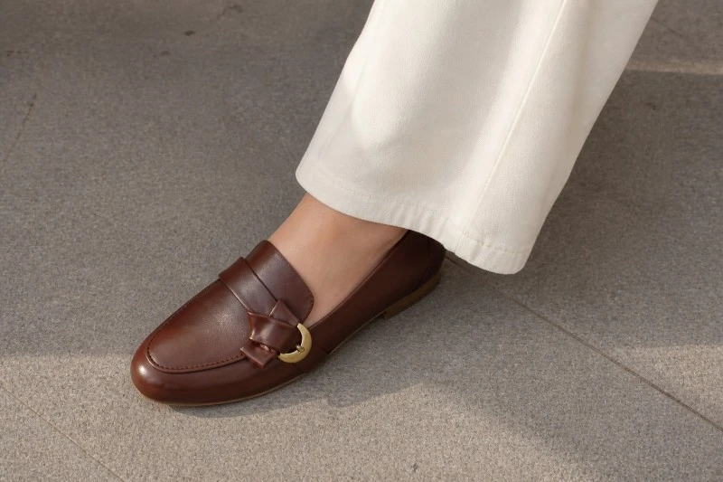 Brown Leather Women's Loafer Worn with Cream Trousers Brown Leather Women's Loafer Worn with Cream Trousers